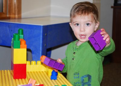 A Little Boy Playing With Colorful Blocks