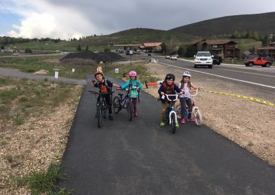 A Group of Children Cycling ALong a Road